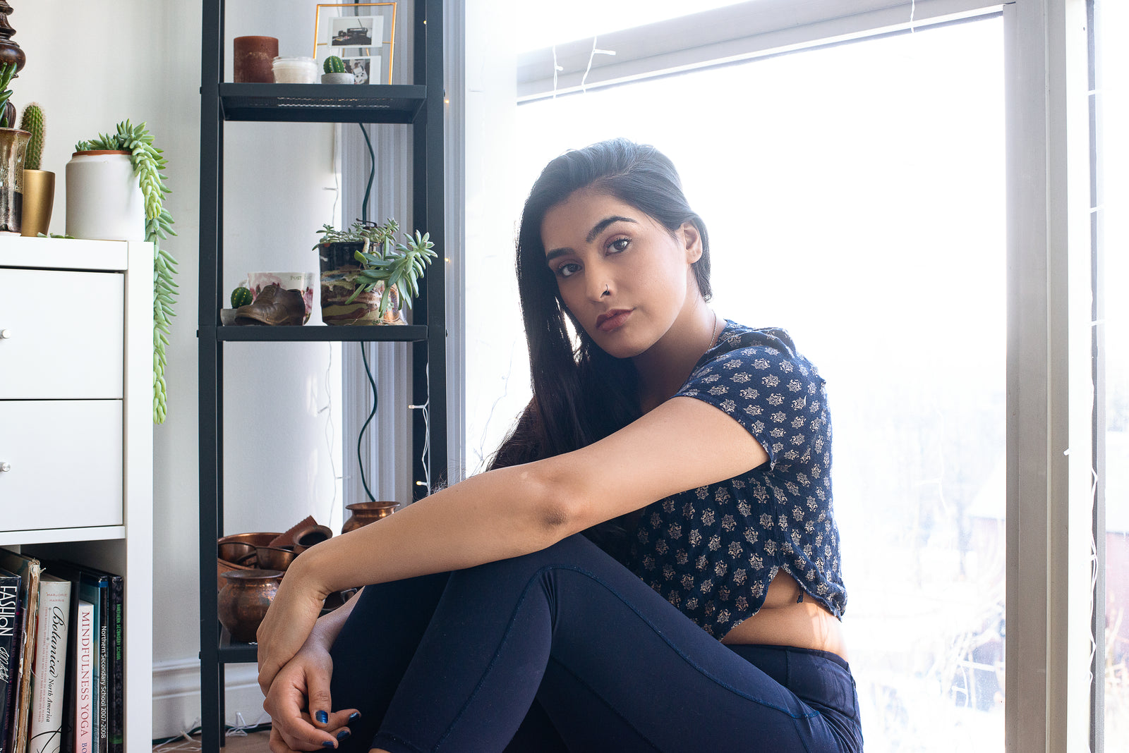 A woman sitting quietly by a bright window